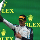 A photo of George Russell holding a trophy on the podium.